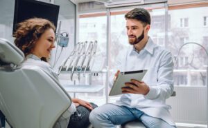 A woman and dentist sitting in a dental office during a cosmetic dentistry consultation.
