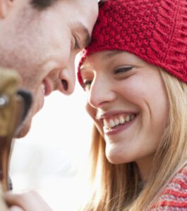 A man and a woman smiling confidently at each other.