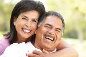 A mature man and woman with complete smiles thanks to dental bridges in Lewisville.