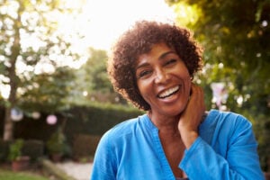 A woman smiling confidently thanks to dental crowns in Lewisville.