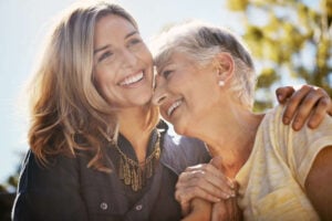 A young woman and a mature woman, both smiling proudly.