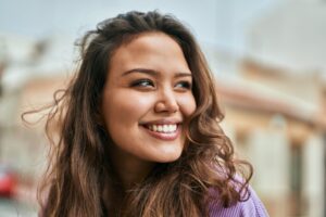 Smiling young woman dental patient looks off in the distance after getting composite fillings.