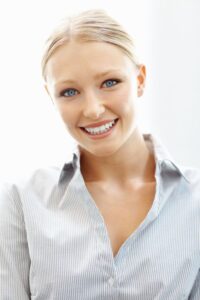 A young woman smiling after replacing metal fillings in Lewisville.