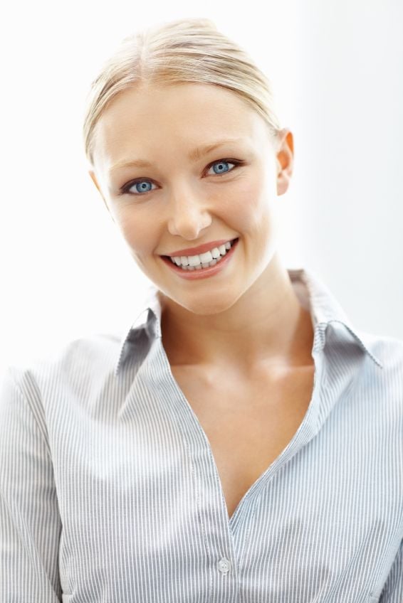 A young woman smiling after replacing metal fillings in Lewisville.