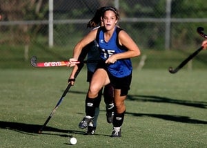 A young woman playing field hockey at school after her six month dental checkup in Lewisville.